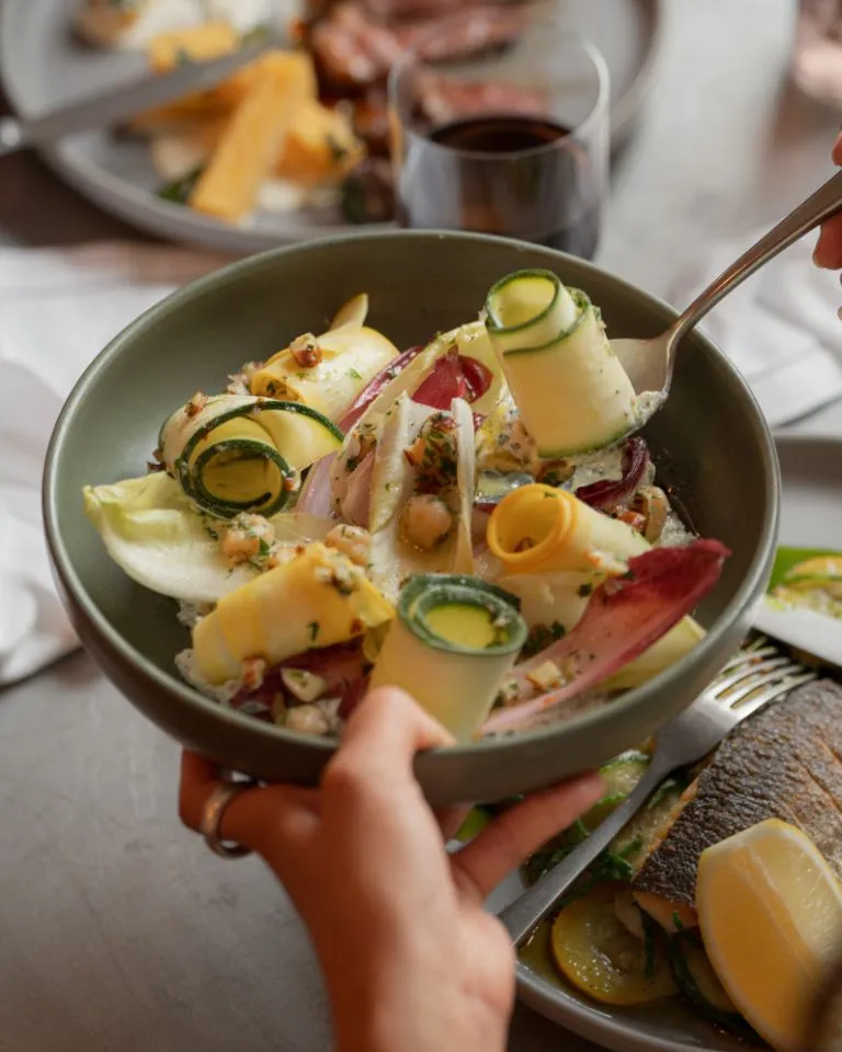 Marinated courgette salad passed over table