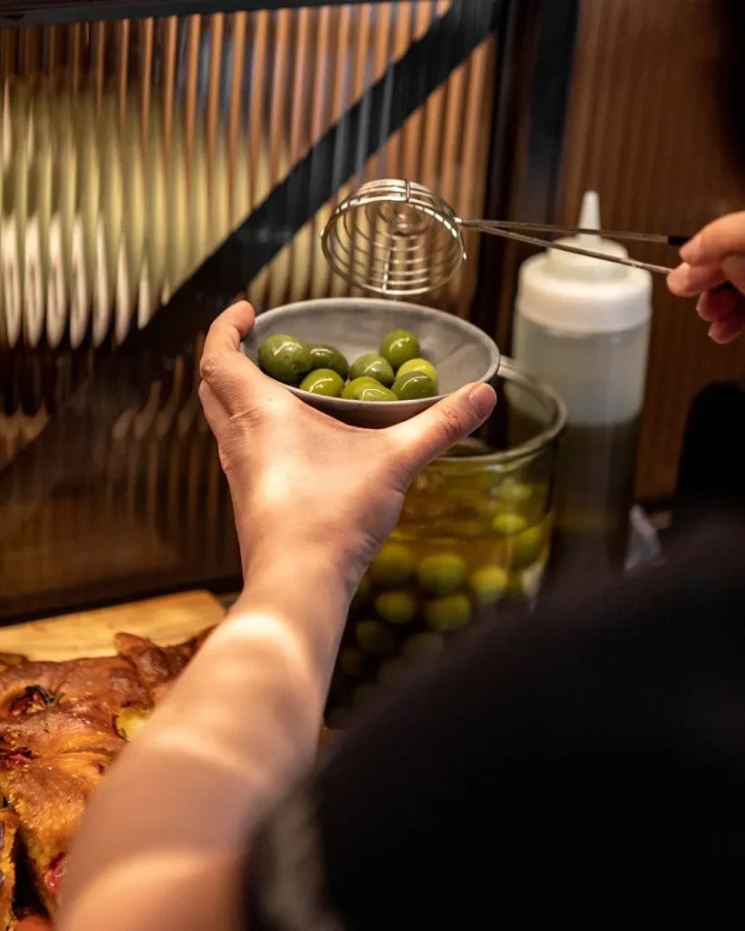 Person plating up Nocellara olives