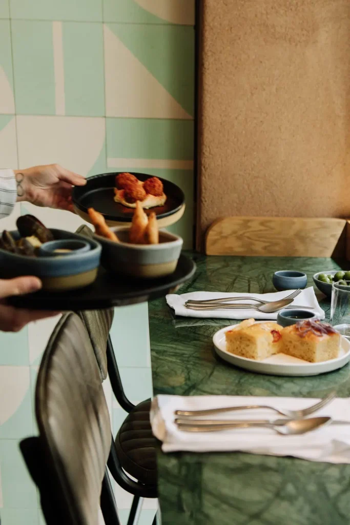 Person serving a tray of small plates